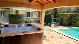 vue depuis le poolhouse sur le jacuzzi, la piscine et vers la terrasse du gîte L'Olivier d'Alana à Massanes